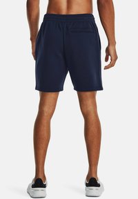 Bermudas de entrenamiento azul marino con cintura elástica, bolsillos laterales y un único bolsillo trasero; fabricadas con una tela suave y texturizada.