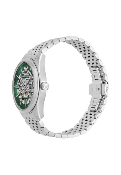 Silberne Metall-Armbanduhr mit grünem Skelett-Zifferblatt, sichtbaren Zahnrädern, römischen Ziffern und Gliederarmband mit Faltschließe.