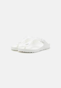 Hvite flip-flop sandaler laget av fleksibelt materiale med en glatt tekstur, med en tåpost og sidestropp for justering.