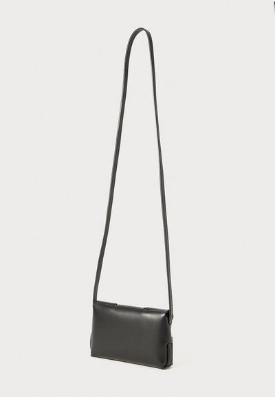 Geantă de umăr din piele neagră, cu o curea lungă, formă rectangulară, textură netedă și design minimalist. Fără hardware sau accente vizibile.