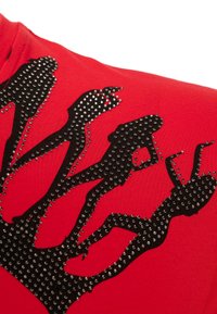 Rotes Baumwoll-T-Shirt mit einem schwarzen Silhouetten-Design, das mit silbernen Nieten verziert ist und verschiedene posierende Figuren darstellt.
