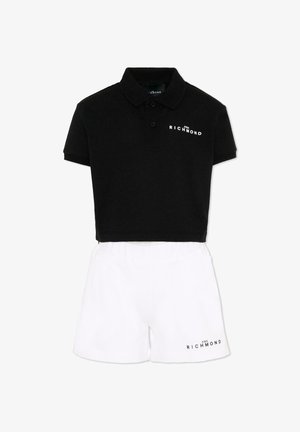 Set composto da polo nera corta e pantaloncini bianchi, entrambi con piccoli loghi "John Richmond" sul davanti.