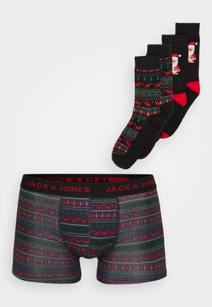 Schwarze Boxershorts für Männer mit rot-grünem Rentier-Muster, ausgestattet mit einem schwarzen Bund. Drei Paare thematischer Socken mit festlichen Designs.