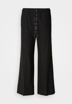 Zwarte, wijde broek met een elastische tailleband en zwarte koord. Gemaakt van een gladde stof zonder zichtbare patronen of hardware.