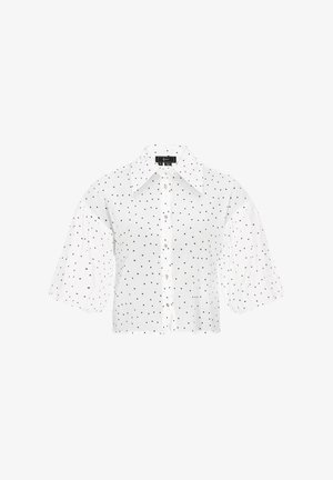 Hvid kortærmet skjorte med store puffærmer, med knaplukning foran og sorte prikker over det hele.