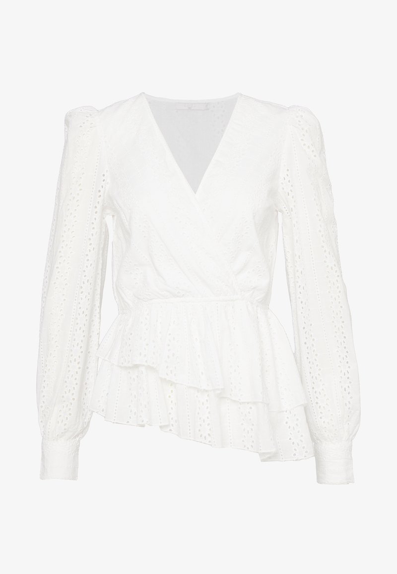 Blouse blanche à manches longues portefeuille avec motif ajouré en dentelle, manches bouffantes, poignets ajustés et bas asymétrique à volants superposés.