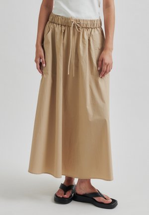 Beige sukni ke kotníkům s elastickým pasem a šňůrkou. Hladký, lehký materiál a pohodlný střih.