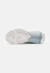 Shoe sole featuring a rounded shape, white rubber material, textured tread pattern, and a translucent blue midsole section.