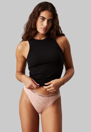Top en maille noire à col haut, associé à un string rose clair avec des bordures en dentelle et une ceinture de marque noire.