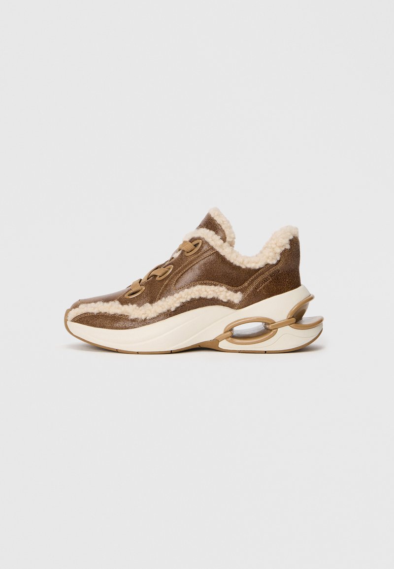 Brown leather sneaker with shearling accents, rounded toe, lace-up closure, and a thick, white midsole featuring circular cutouts.