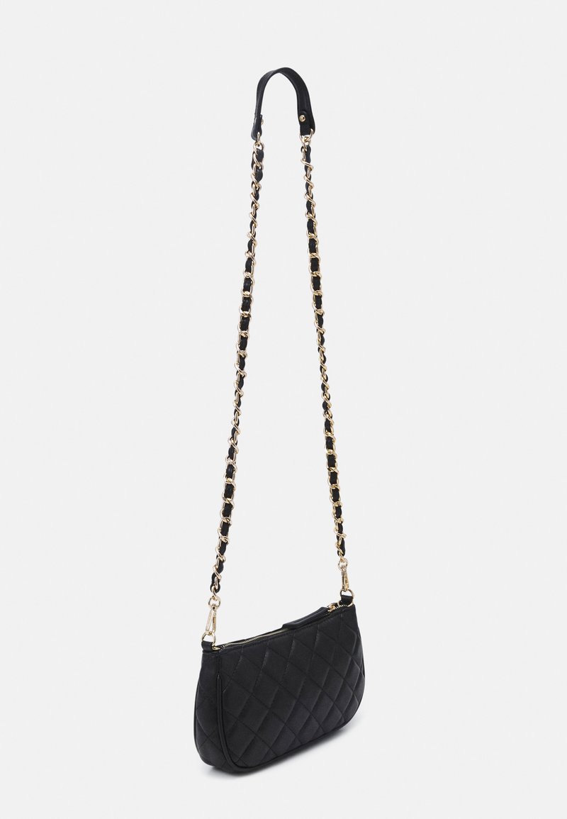 Schwarze, gesteppte Handtasche mit einer geschwungenen Form, die über einen goldfarbenen Kettenriemen und schwarze Lederakzente verfügt. Reißverschlussverschluss an der Oberseite.