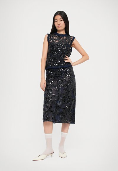 Completo due pezzi blu navy con top aderente senza maniche e gonna a tubino al ginocchio. Caratterizzato da un tessuto testurizzato e bordi arricciati.