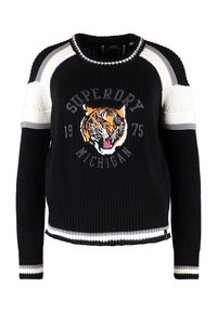 Pull en maille noire avec un col rond, présentant un graphisme de tigre, le texte "Superdry Michigan", et des accents rayés en gris et blanc.