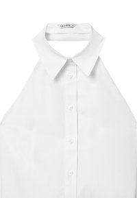 Camicetta bianca senza maniche con colletto classico, chiusura anteriore con bottoni e texture liscia, realizzata in un materiale di cotone leggero.