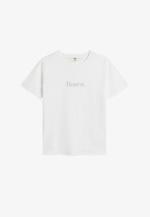 Camiseta de algodón blanca con mangas cortas y cuello redondo, con la palabra "Honesto" impresa en sutil texto plateado en la parte delantera.