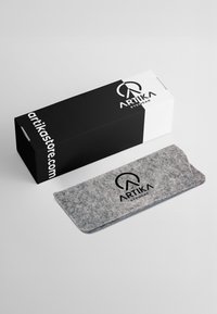 Astuccio per occhiali grigio con logo nero, posizionato accanto a una scatola bianca e nera etichettata "ARTIKA EYEWEAR".