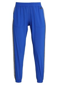 Blå träningsbyxor i lätt material, med elastisk midja, två framfickor och svarta sidostråk längs benen.