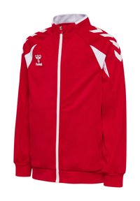 Veste de sport rouge et blanche à fermeture éclair avec col montant, rayures blanches en forme de chevron sur les épaules, et logo hummel sur la poitrine gauche.