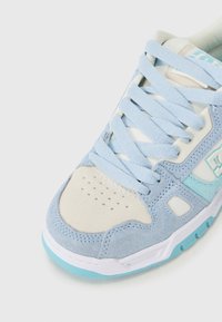 Blue and cream sneaker featuring suede and mesh upper, thick laces, perforated toe cap, and light blue accents on the outsole.