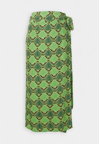 Jupe enveloppante à motif vert présentant un design de coquillage répétitif en vert foncé et avec des accents jaunes, dotée d'une taille nouée et d'une texture de tissu douce.