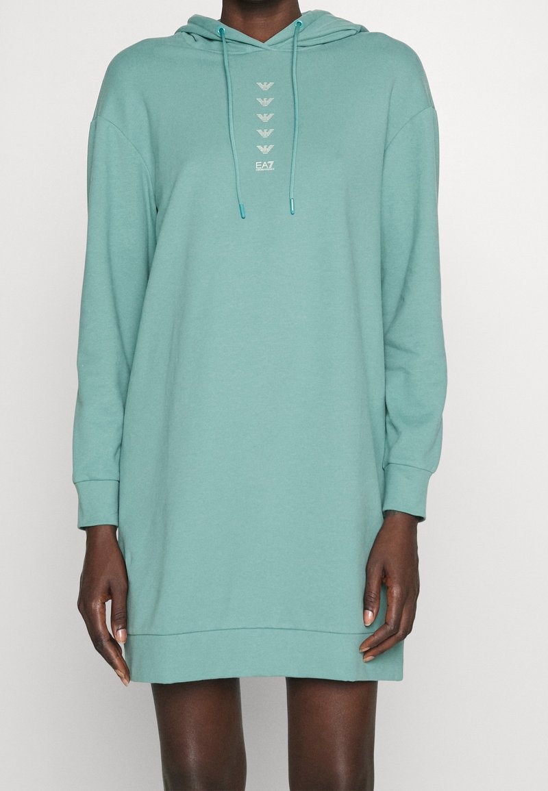 Huvtröja med lång ärm i mjukt teal-färgat tyg. Har EA7-logotypdetalj i silver nedan mitt och en avslappnad, oversized passform.