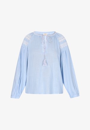 Gaiši zila blūze ar garām piedurknēm, apaļu kakla izgriezumu, saites detaļu un izšūtas akcentus uz pleciem. Izgatavota no mīkstas, teksturētas auduma.