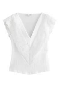 Haut blanc avec un décolleté en V profond et une superposition de dentelle, présentant un tissu texturé et des manches courtes. Motif en dentelle festonné détaillé le long des bords.