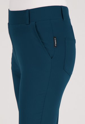 Slim-fit teal broek met voor- en achterzakken, voorzien van een klein zwart label met witte tekst op de naad van de zijzak.