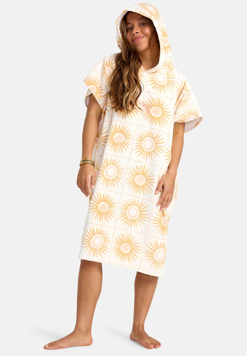 Poncho de toalla con capucha en blanco con un patrón de rayos de sol amarillos. Textura de rizo suave, corte holgado y mangas cortas.