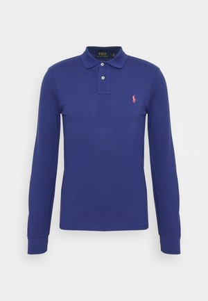 Navyblaue Poloshirt mit langen Ärmeln, zwei Knöpfen, gerippten Bündchen und einem kleinen pinkfarbenen, aufgestickten Logo auf der linken Brust.