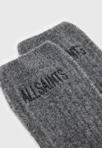 Grijze wollen sokken met een geribbelde textuur en het reliëflogo "ALLSAINTS". Ze hebben een zachte, donzige afwerking en een rechthoekige vorm.