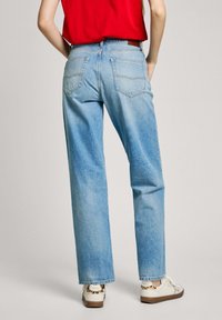 Zili zili džinsi ar brīvu piegriezumu, ar divām aizmugures kabatām, maigu šuvju detaļām un taisnu kāju dizainu.