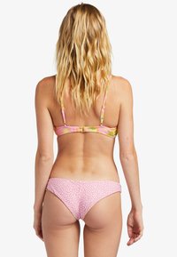 Bikini multicolore con una stampa floreale pastello sulla parte superiore, dotata di spalline morbide e un fondo rosa unito con una finitura testurizzata.
