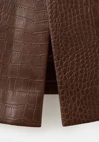 Brunt læderstof med to forskellige prægede krokodilleskindsmønstre, et med større rektangulære skæl og det andet med mindre, afrundede skæl.