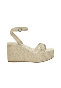 Sandales compensées tissées beiges avec un design en corde tressée, une sangle de cheville réglable et une semelle épaisse pour plus de hauteur.