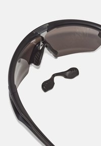 Schwarze Sonnenbrille mit gekrümmtem Design, getönten Gläsern und Gummibezügen. Enthält ein abnehmbares Nasenteil für eine anpassbare Passform.