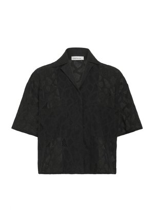 Tricou negru cu mânecă scurtă, prezentând un design geometric din dantelă texturată, guler decupat și o croială lejeră care favorizează respirabilitatea.