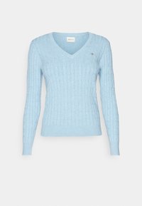 Jasnoniebieski sweter z dzianiny w warkocze, z dekoltem w serek i długimi rękawami, z małym naszytym logo na lewej piersi.