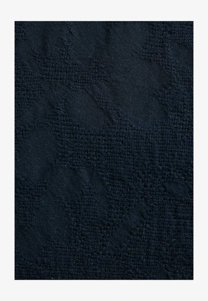 Textured dark navy fabric with a subtle pattern. The surface features a mix of woven and smooth areas, providing a varied tactile experience.