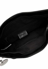 Interior de bolso de mano de cuero negro con una textura suave, que cuenta con un bolsillo con cremallera y un bolsillo abierto. Cierre con cremallera; etiqueta de marca en el interior.