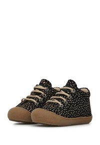 Scarpe da ginnastica nere con motivo a pois, lacci beige e suola in gomma testurizzata. Punta arrotondata e design a metà altezza.