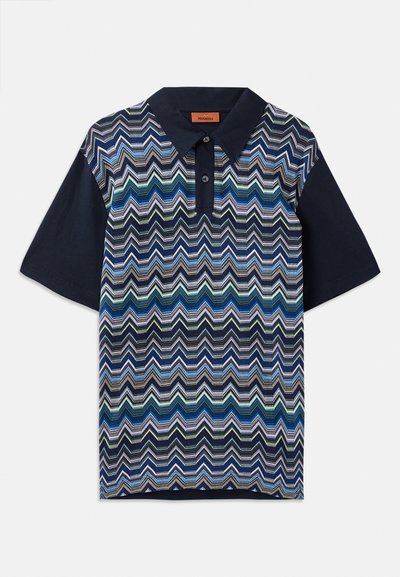 Camisa polo com um padrão em zigue-zague nas cores azul, verde e branco, com mangas azul-marinho escuras e colarinho azul-marinho sólido. Inclui uma abertura com dois botões.