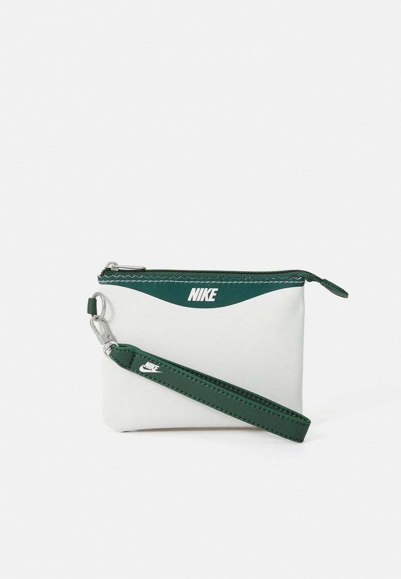 Buzunar Nike alb cu accente verzi. Dispune de închidere cu fermoar, curea pentru încheietura mâinii și un logo pe față. Textură netedă, design compact.