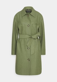 Oliivinvihreä villasekoitteen takki, jossa on lovellinen kaulus, etupainikkeet, kaksi suurta taskua ja sidottava vyö vyötäröllä. Pitkät hihat ja suora leikkaus.