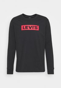 Svart långärmad t-shirt i bomull med rund halsringning. Har en central röd Levi's-logotyp på en rektangulär lapp.