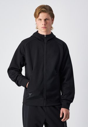 Zwarte zip-up hoodie gemaakt van gladde stof. Kenmerkt een hoge kraag, twee zijzakken en een klein logo nabij de zoom. Eenvoudig, sportief ontwerp.