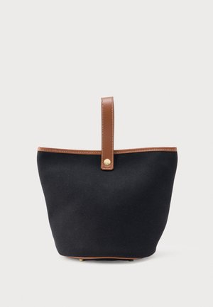 Μαύρη υφασμάτινη τσάντα tote με καφέ δερμάτινο λουράκι και περιθώρια, με χρυσή λεπτομέρεια κουμπιού στο λουράκι.