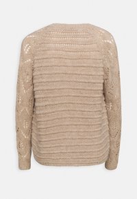 Beige stickad tröja med en texturerad, randig mönstring och öppet arbete på ärmarna. Har en rund halsringning och avslappnad passform.