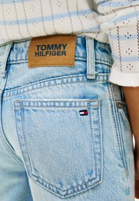 Φωτεινά γαλάζια τζιν παντελόνια από denim με δερμάτινη ετικέτα της μάρκας Tommy Hilfiger και μικρό έμβλημα σημαίας στην πίσω τσέπη. Διακριτή ξεθωριασμένη υφή.