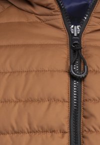 Brązowa kurtka puchowa z poziomym pikowaniem, czarnym zamkiem, kapturem ze sznurkiem i ciemnoniebieskim podszyciem. Gładka tekstura.